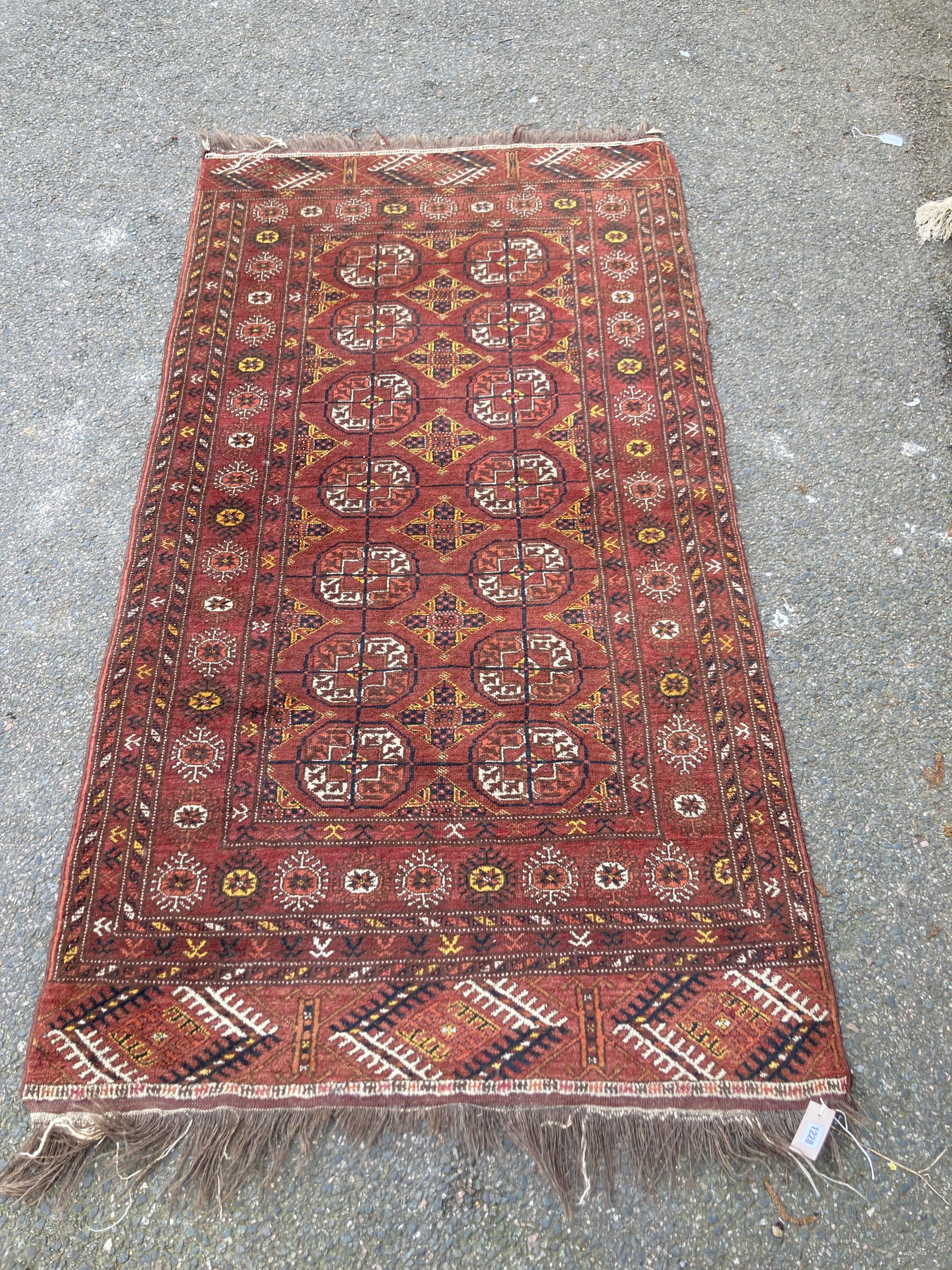 A Bokhara burgundy ground rug, 210 x 113cm